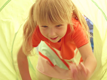 girl crawling through tunnel